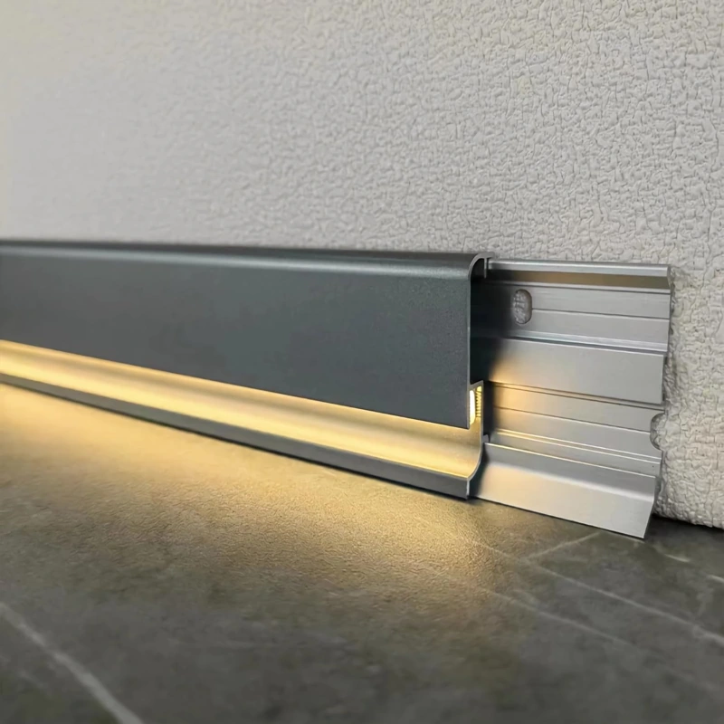 Grey aluminum LED skirting board with wall-mount bracket.